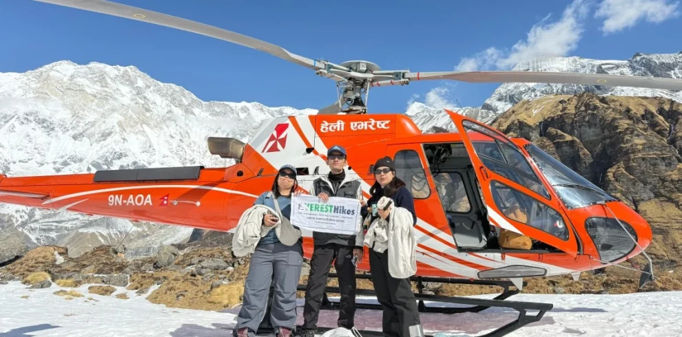 Travelers on an ABC Heli Tour Nepal taking a photo beside a helicopte